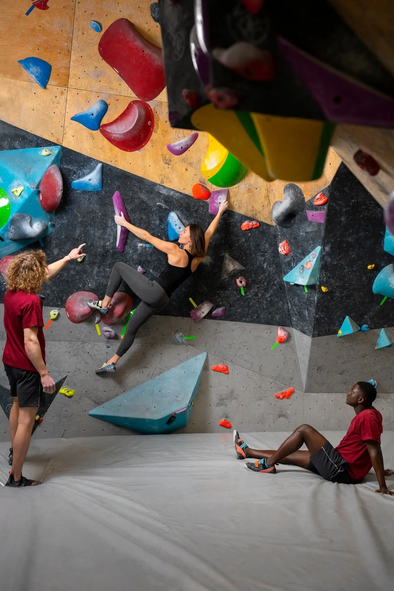 Снимок в полный рост: женщина карабкается по стене.